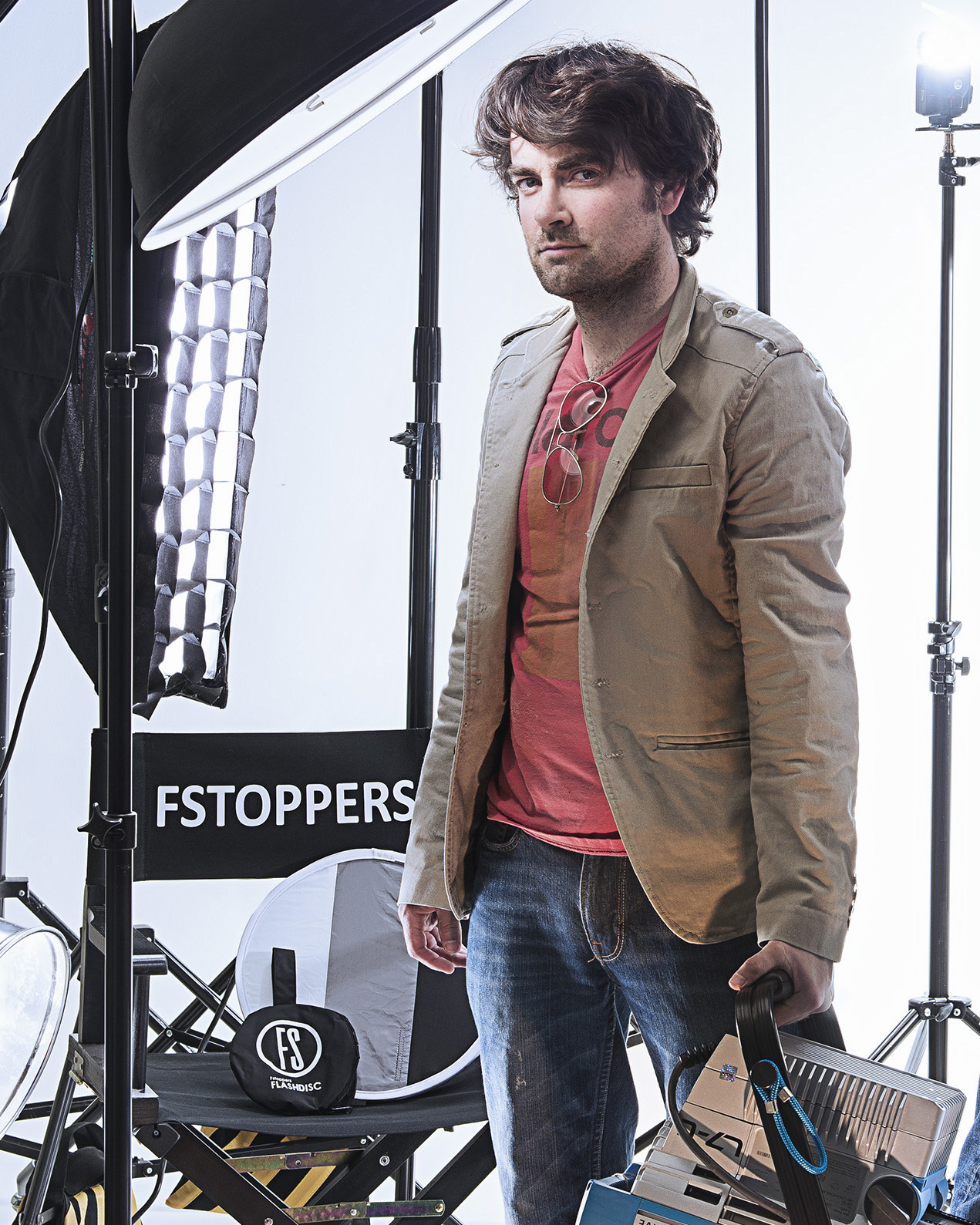 Patrick Hall standing in a photo studio next to softbox lights and an FSTOPPERS branded scrim