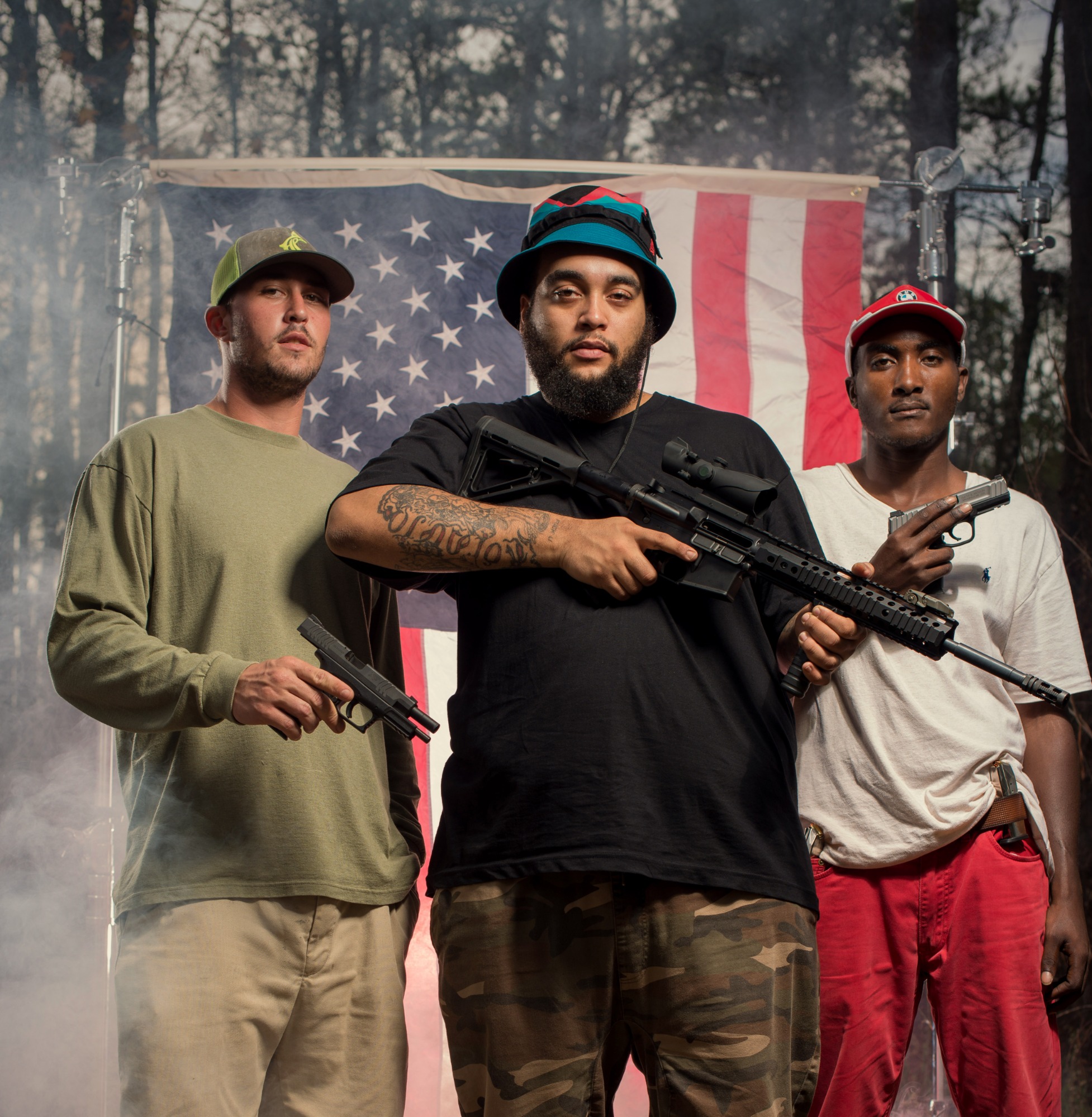 Portrait 10 from the An American Christmas series, person posing with a hunting rifle in front of an American flag backdrop