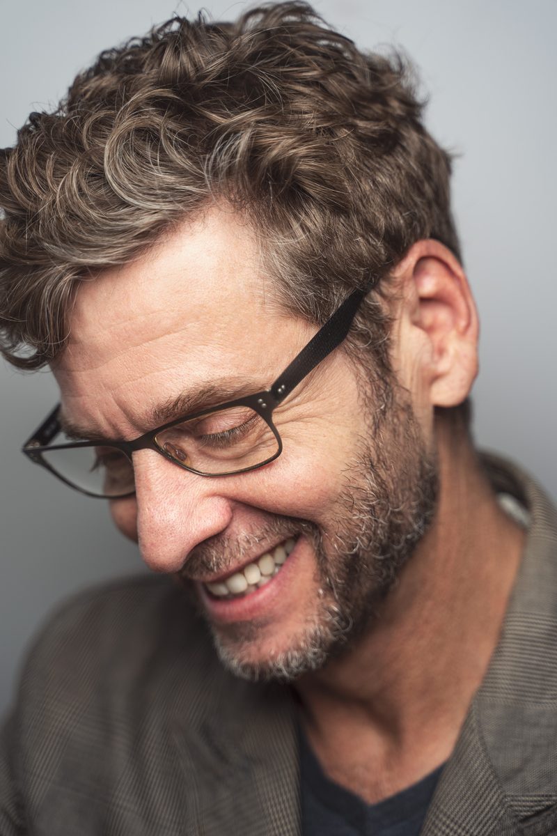 Man with glasses smiling, close-up portrait