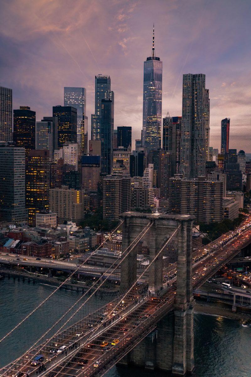Aerial view of the Brooklyn Bridge with the Lower Manhattan skyline at dusk