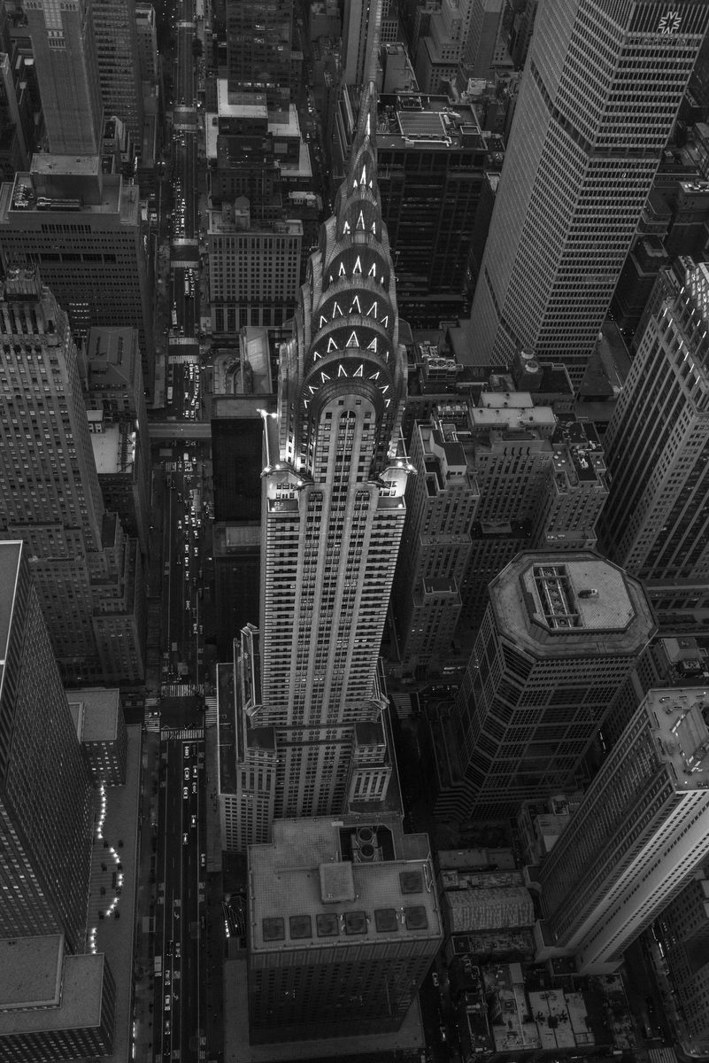 Black-and-white aerial view looking straight down on the Chrysler Building among Manhattan skyscrapers