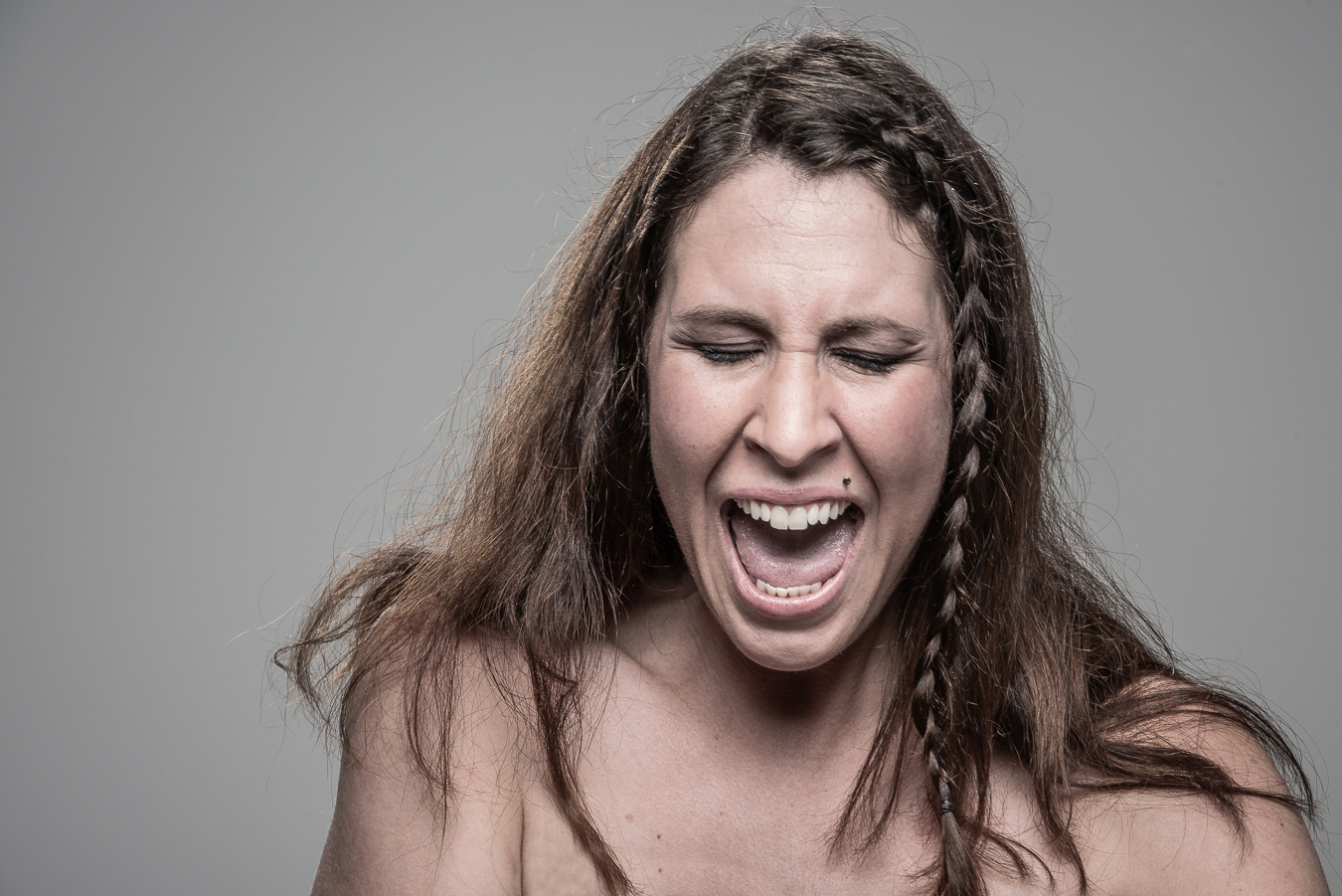 Studio headshot portrait 3 from the Stun Gun Photoshoot series, person flinching and grimacing as they are hit with a stun gun