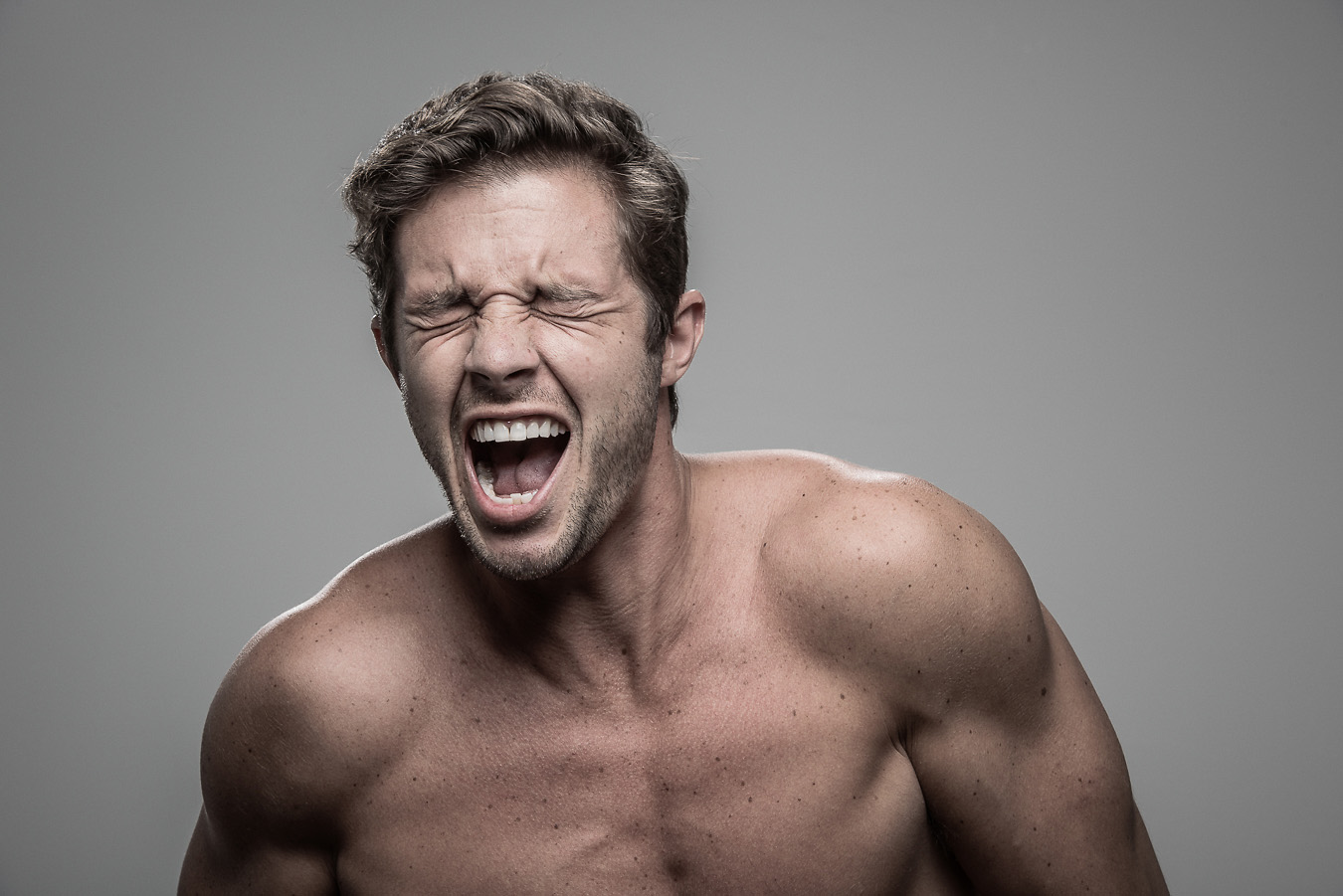 Studio headshot portrait 4 from the Stun Gun Photoshoot series, person crying out mid-shock as they are hit with a stun gun