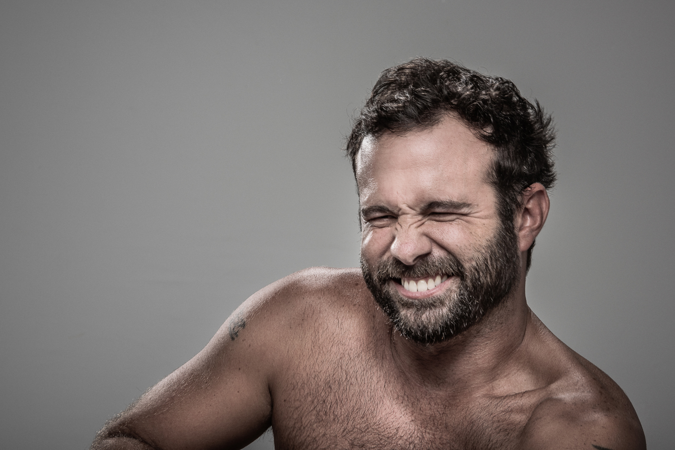 Studio headshot portrait 9 from the Stun Gun Photoshoot series, person flinching and grimacing as they are hit with a stun gun