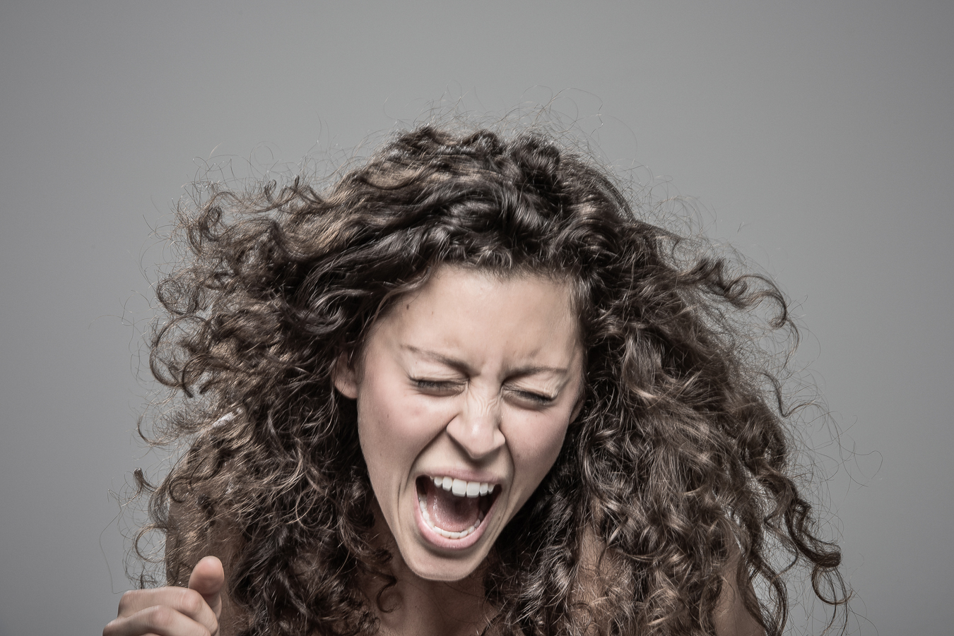 Studio headshot portrait 11 from the Stun Gun Photoshoot series, person recoiling with a startled laugh as they are hit with a stun gun