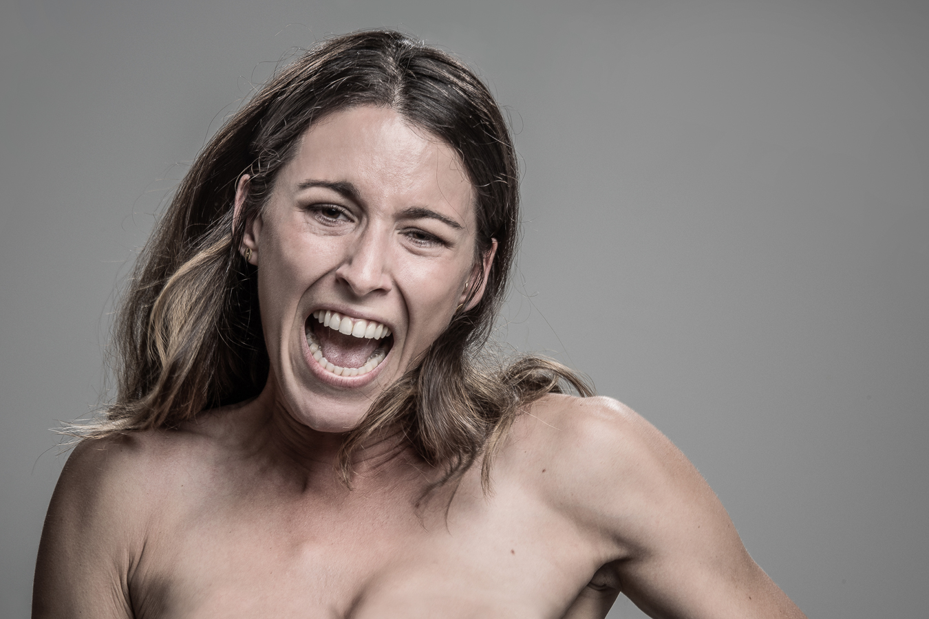 Studio headshot portrait 15 from the Stun Gun Photoshoot series, person flinching and grimacing as they are hit with a stun gun