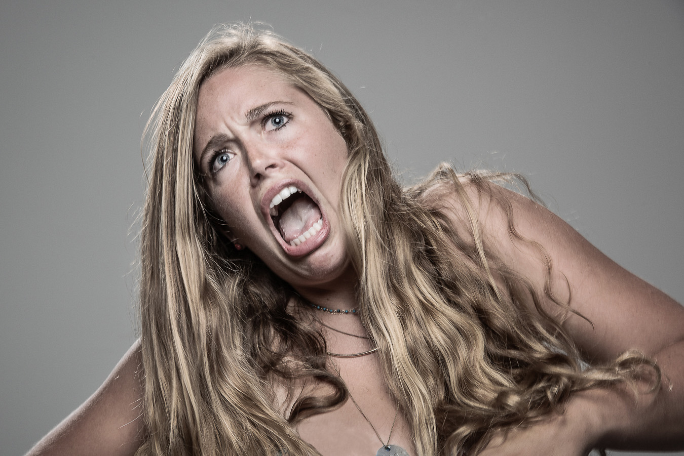 Studio headshot portrait 17 from the Stun Gun Photoshoot series, person recoiling with a startled laugh as they are hit with a stun gun