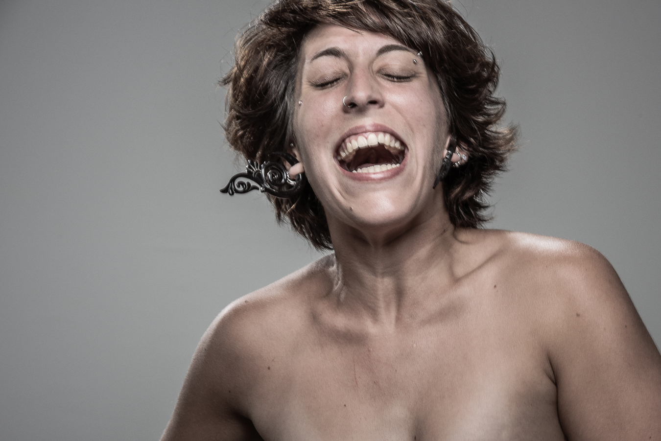 Studio headshot portrait 19 from the Stun Gun Photoshoot series, person wincing with eyes shut as they are hit with a stun gun