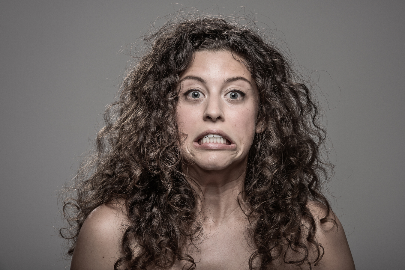 Studio headshot portrait 21 from the Stun Gun Photoshoot series, person flinching and grimacing as they are hit with a stun gun