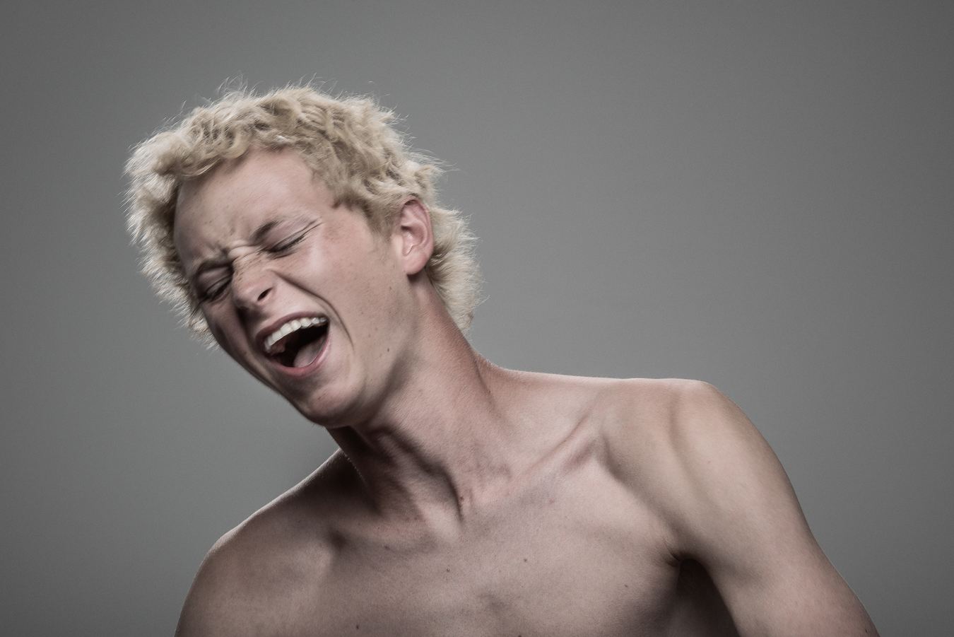 Studio headshot portrait 23 from the Stun Gun Photoshoot series, person recoiling with a startled laugh as they are hit with a stun gun