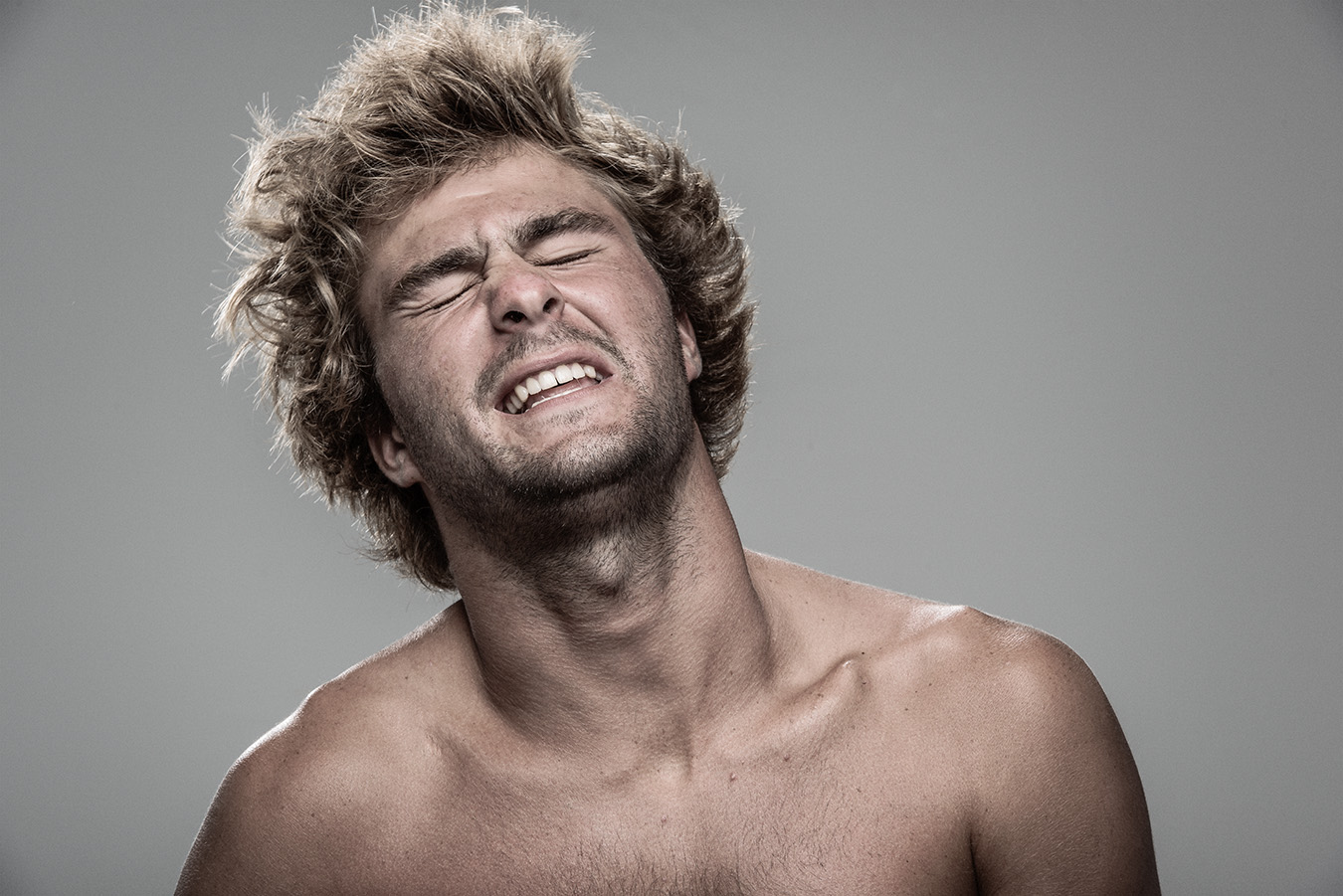 Studio headshot portrait 30 from the Stun Gun Photoshoot series, person grimacing with clenched teeth as they are hit with a stun gun