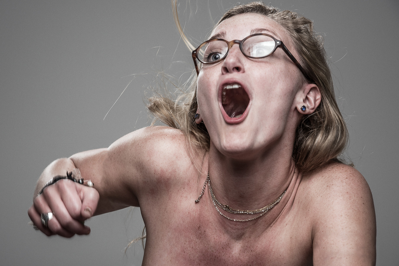 Studio headshot portrait 31 from the Stun Gun Photoshoot series, person wincing with eyes shut as they are hit with a stun gun