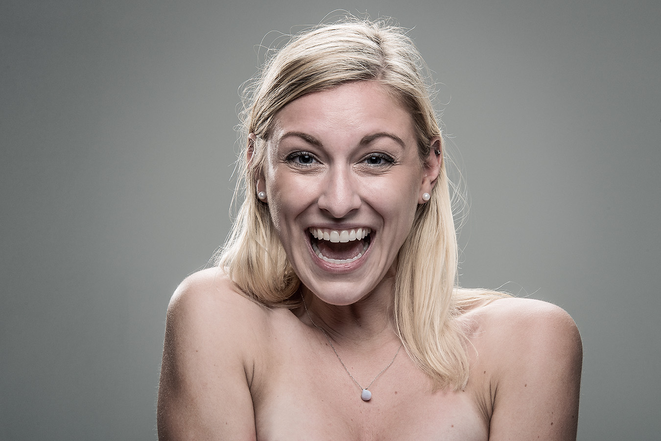 Studio headshot portrait 43 from the Stun Gun Photoshoot series, person wincing with eyes shut as they are hit with a stun gun