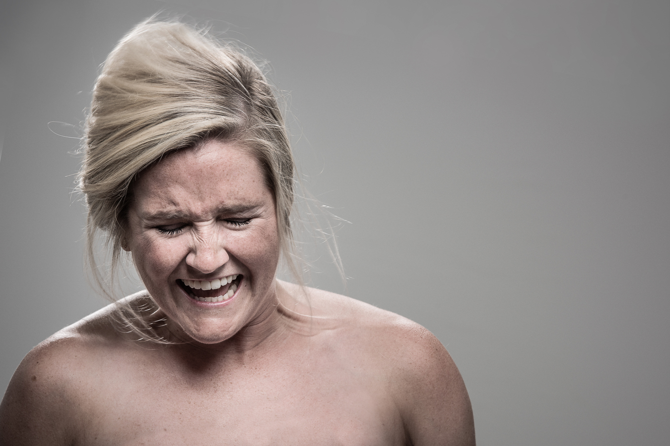Studio headshot portrait 47 from the Stun Gun Photoshoot series, person recoiling with a startled laugh as they are hit with a stun gun