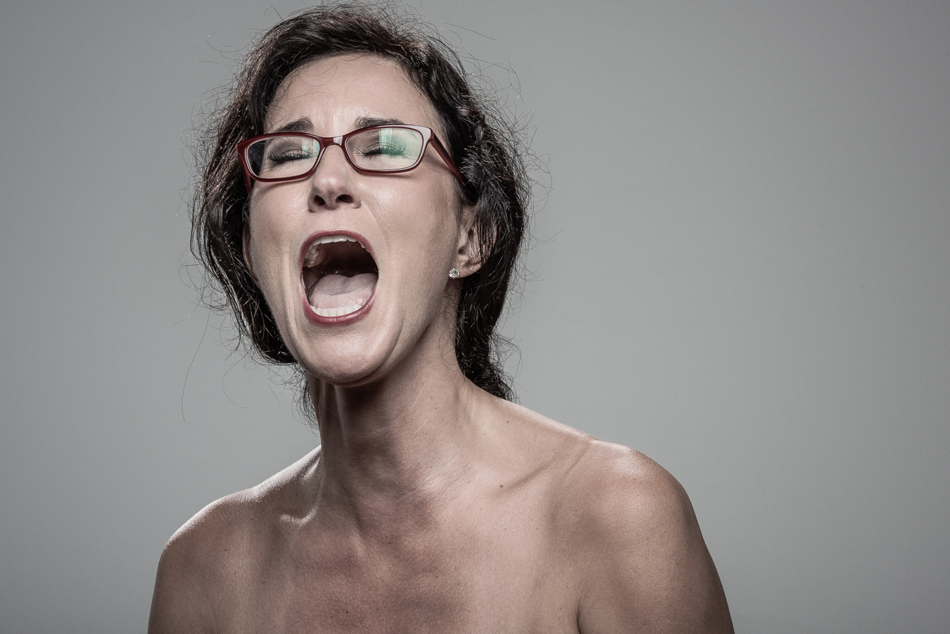 Studio headshot portrait 49 from the Stun Gun Photoshoot series, person wincing with eyes shut as they are hit with a stun gun