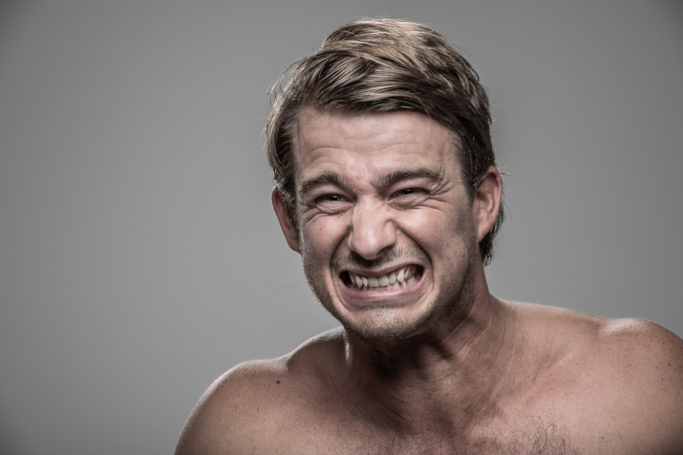 Studio headshot portrait 51 from the Stun Gun Photoshoot series, person flinching and grimacing as they are hit with a stun gun