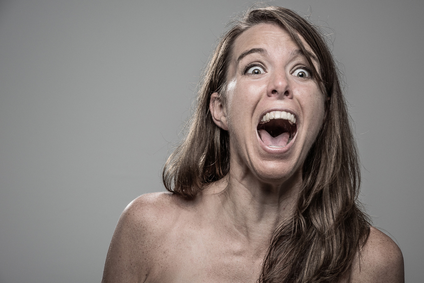 Studio headshot portrait 53 from the Stun Gun Photoshoot series, person recoiling with a startled laugh as they are hit with a stun gun