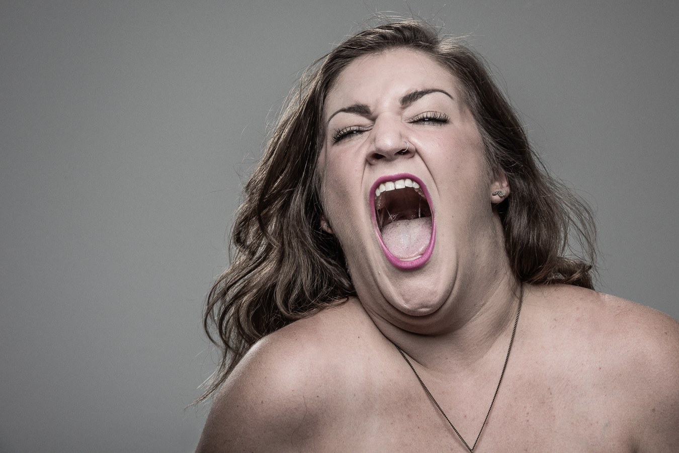 Studio headshot portrait 54 from the Stun Gun Photoshoot series, person grimacing with clenched teeth as they are hit with a stun gun