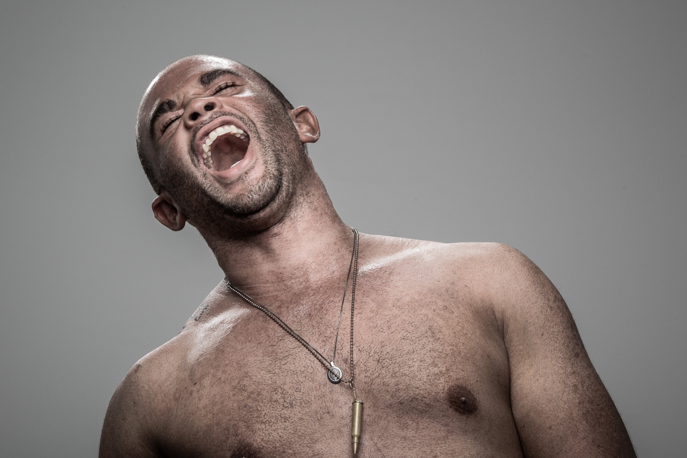 Studio headshot portrait 55 from the Stun Gun Photoshoot series, person wincing with eyes shut as they are hit with a stun gun