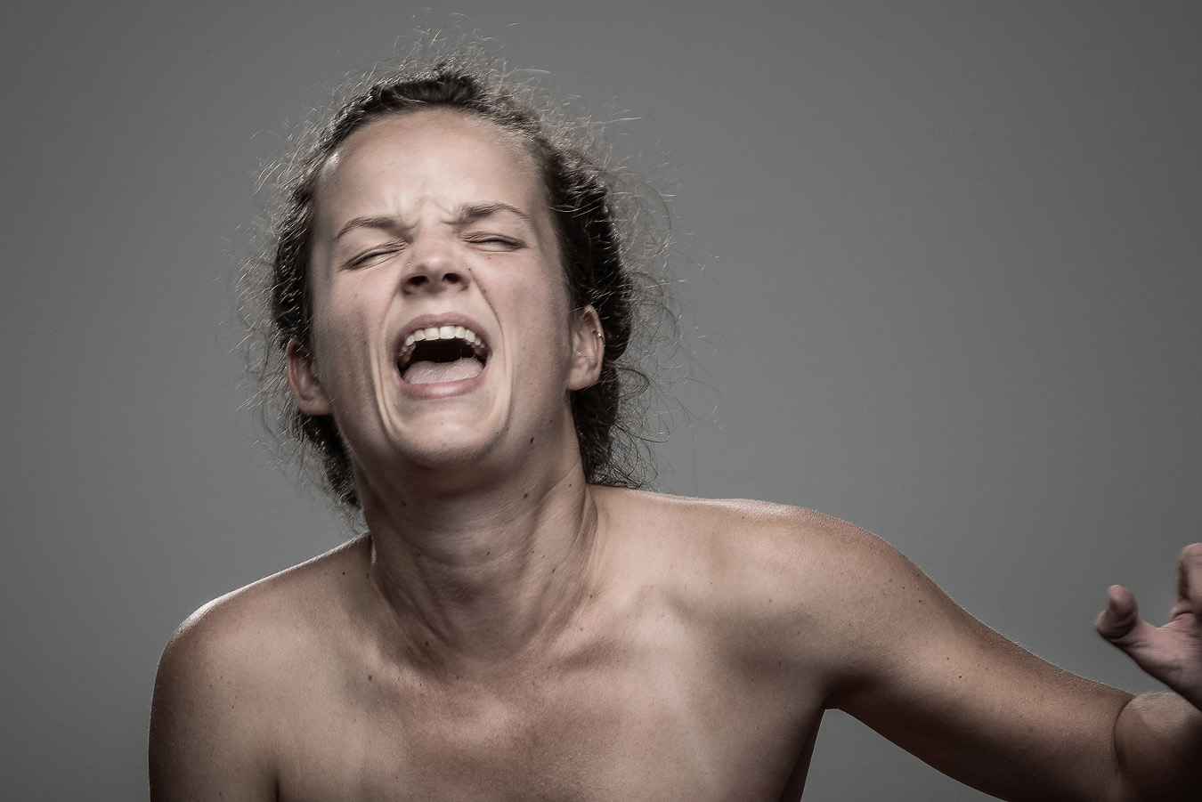 Studio headshot portrait 58 from the Stun Gun Photoshoot series, person crying out mid-shock as they are hit with a stun gun