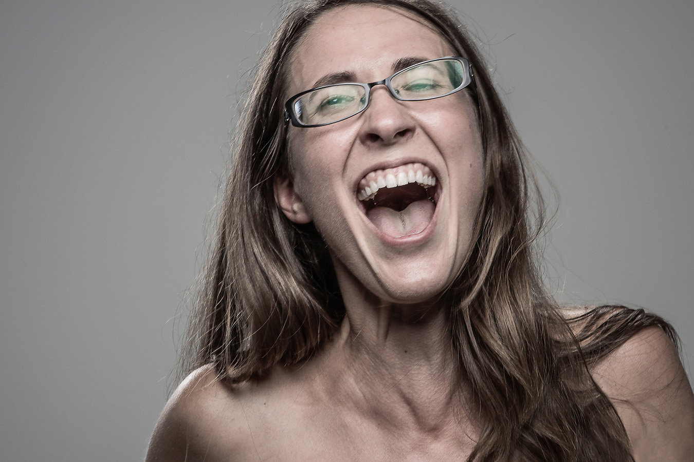 Studio headshot portrait 60 from the Stun Gun Photoshoot series, person grimacing with clenched teeth as they are hit with a stun gun