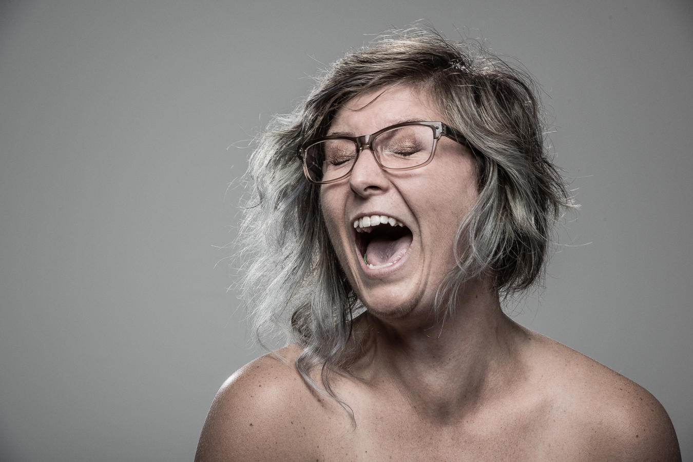 Studio headshot portrait 61 from the Stun Gun Photoshoot series, person wincing with eyes shut as they are hit with a stun gun