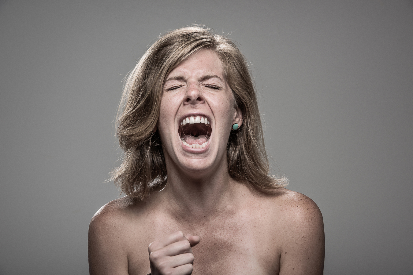 Studio headshot portrait 64 from the Stun Gun Photoshoot series, person crying out mid-shock as they are hit with a stun gun