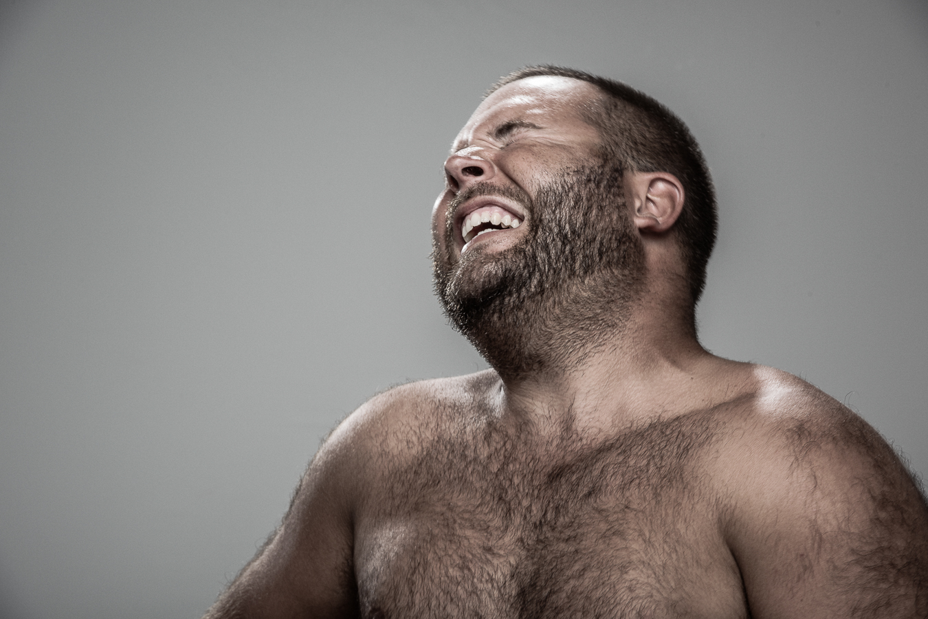 Studio headshot portrait 65 from the Stun Gun Photoshoot series, person recoiling with a startled laugh as they are hit with a stun gun