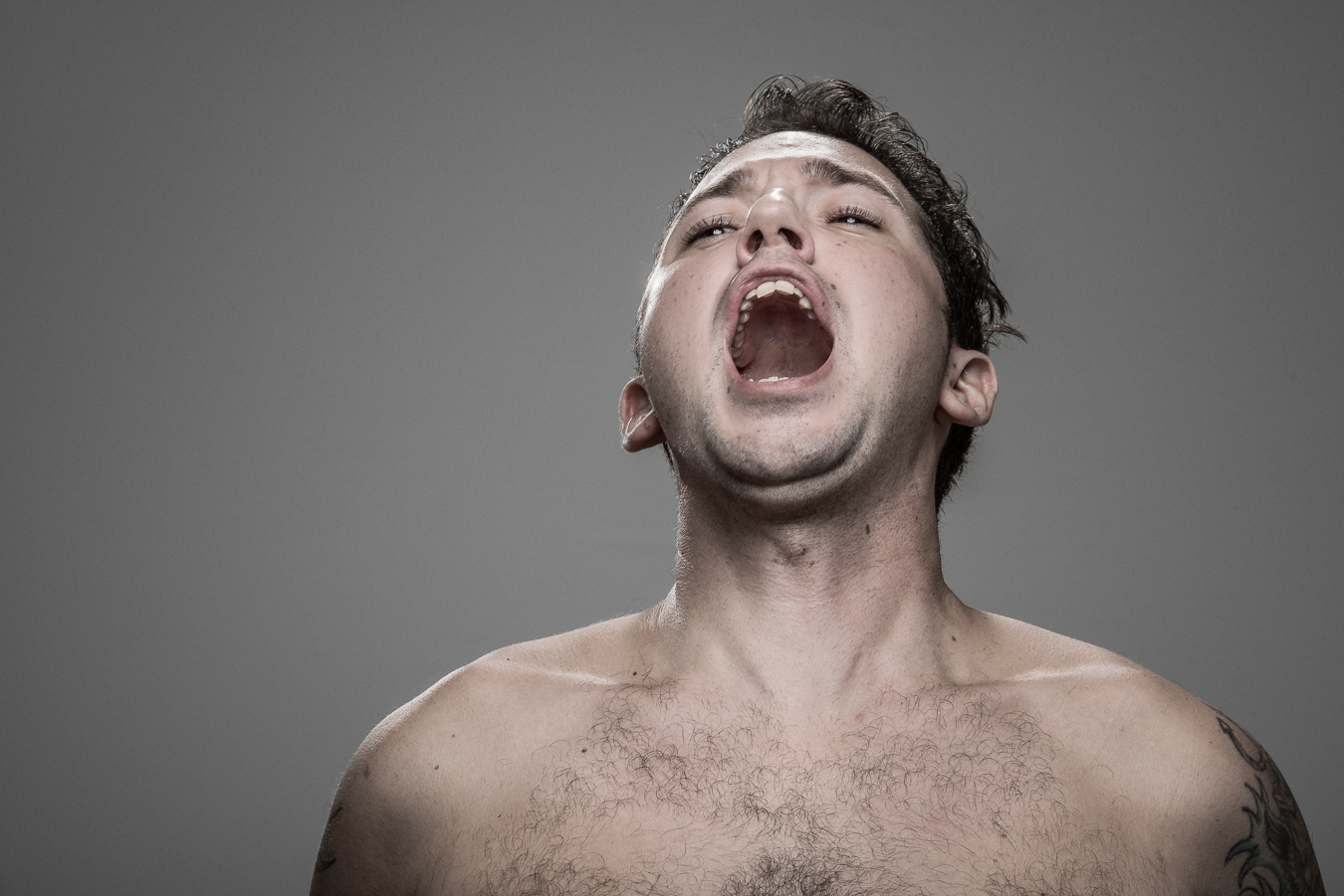 Studio headshot portrait 66 from the Stun Gun Photoshoot series, person grimacing with clenched teeth as they are hit with a stun gun