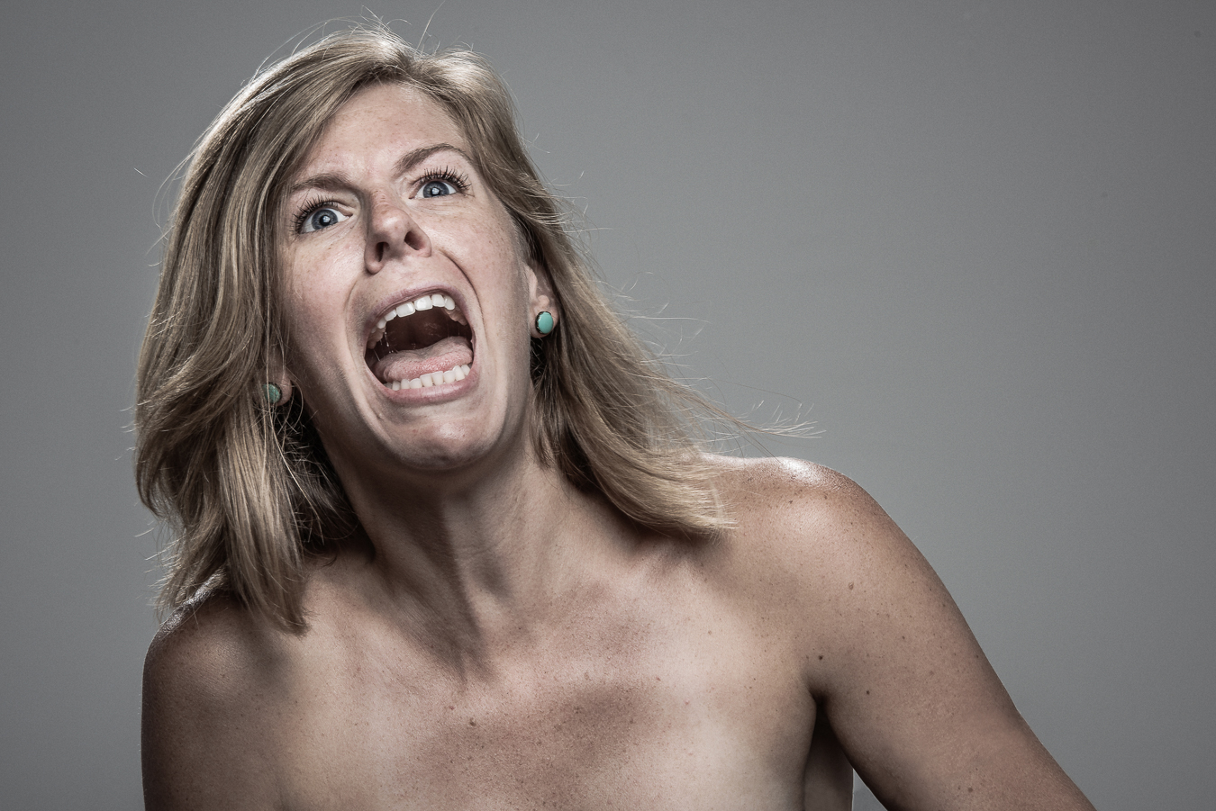 Studio headshot portrait 67 from the Stun Gun Photoshoot series, person wincing with eyes shut as they are hit with a stun gun