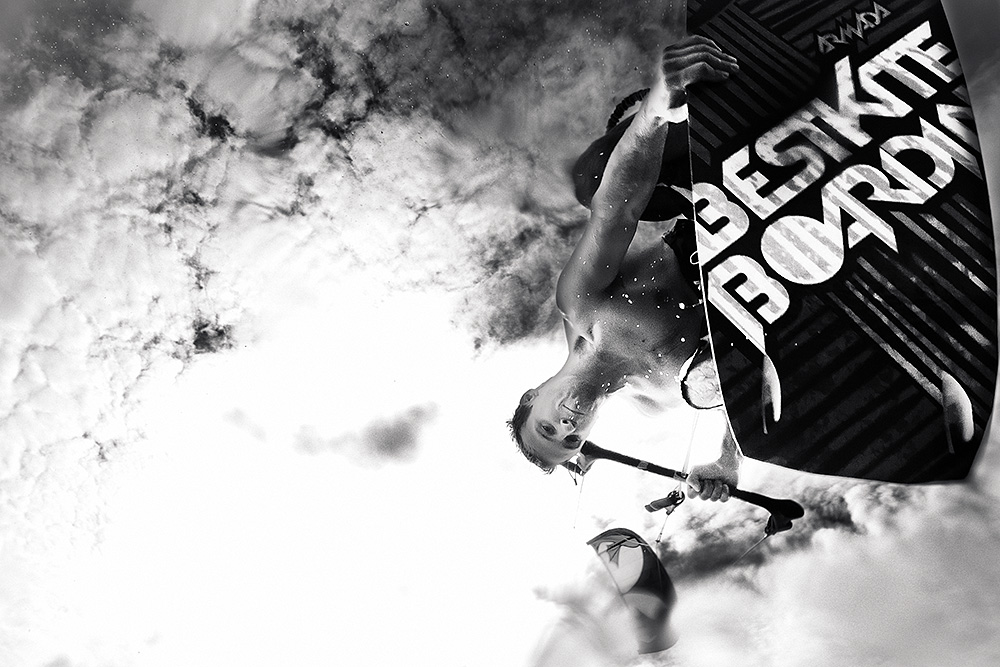 Black and white photo of a wakeboarder jumping through spraying water