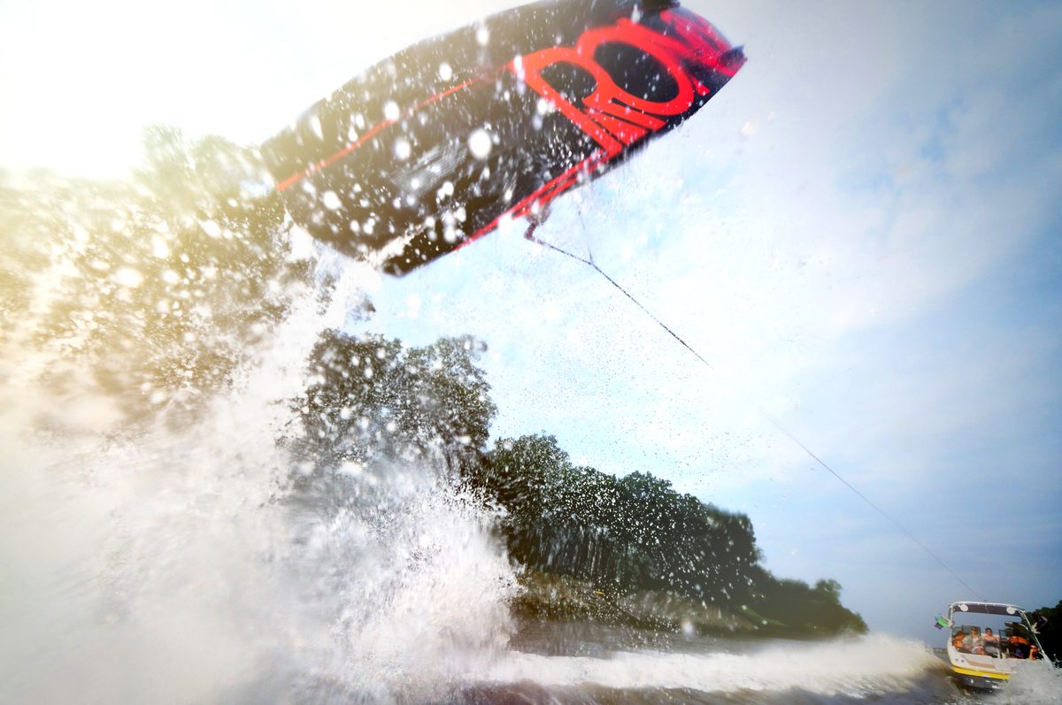 Kiteboarder launching off a wave with a large splash of water